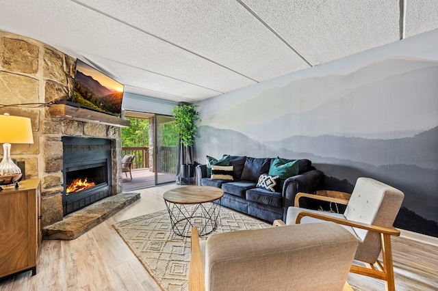 living room featuring a textured ceiling, a fireplace, and hardwood / wood-style floors