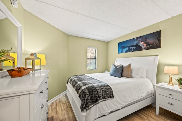 bedroom featuring a textured ceiling and light hardwood / wood-style flooring