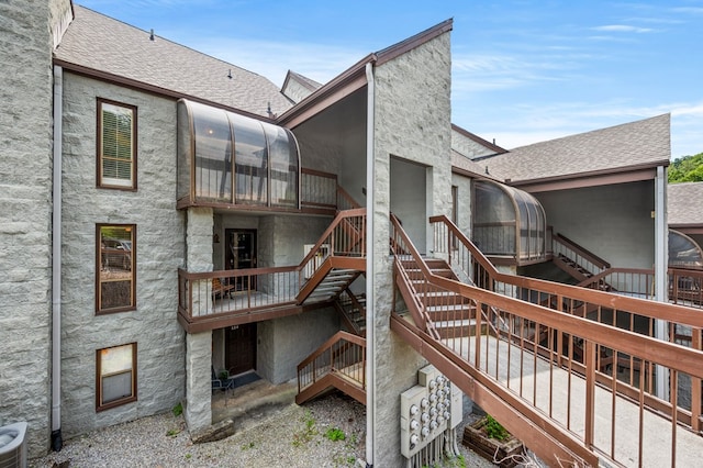 rear view of property featuring central AC and a sunroom