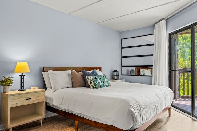 bedroom featuring access to exterior and wood-type flooring