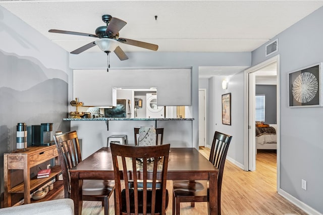 dining area featuring light wood-type flooring and ceiling fan