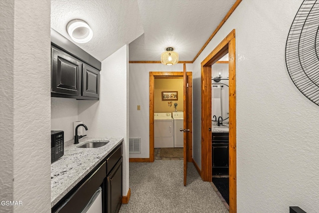 380 Laurel Rd, Townsend, TN 37882 - hallway featuring a sink, a textured wall, washing machine and clothes dryer, a textured ceiling, and light colored carpet