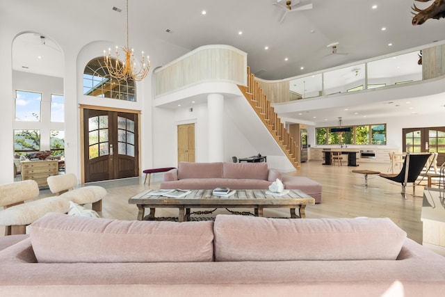 3661 Richardson Cove Rd, Sevierville, TN 37876 - living room with ceiling fan with notable chandelier, light wood-type flooring, a towering ceiling, and a healthy amount of sunlight