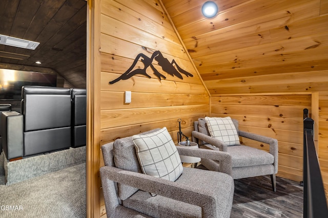 sitting room featuring visible vents, lofted ceiling, wood walls, and wooden ceiling