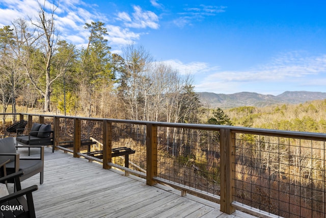 deck featuring a mountain view and a view of trees