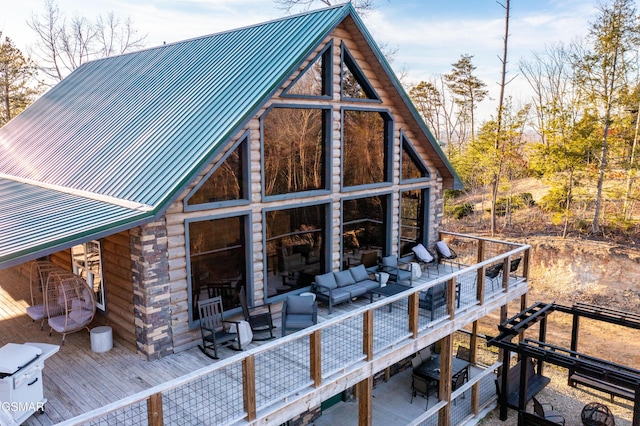 back of house featuring an outdoor living space, metal roof, and a deck