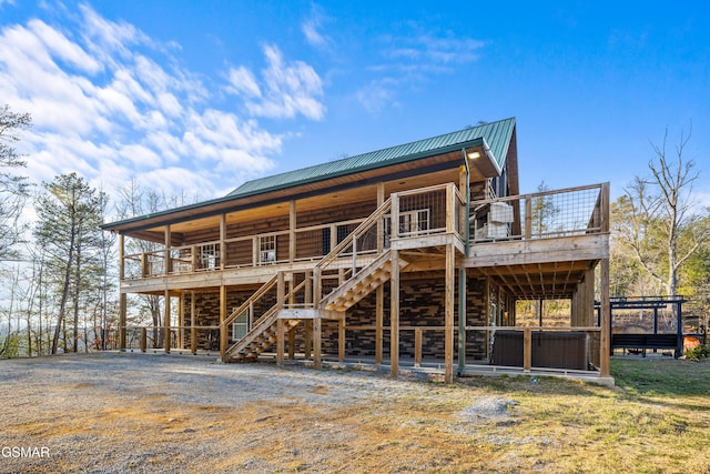 exterior space with metal roof, a wooden deck, and stairway