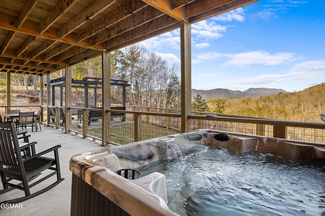 view of patio with a mountain view and a hot tub