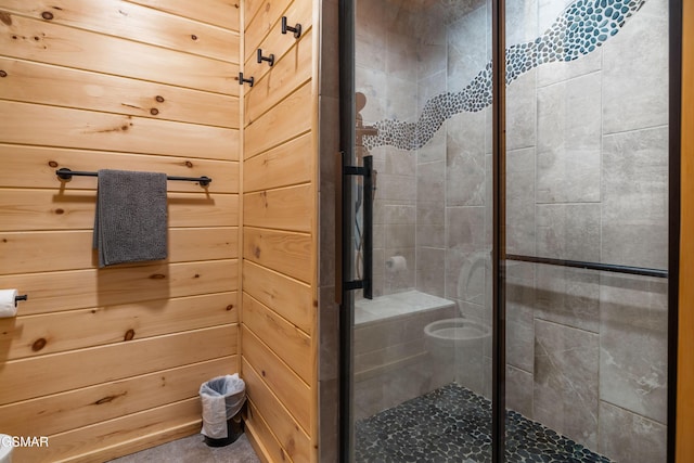 full bathroom with a shower stall and wood walls