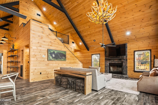 living area with beam ceiling, high vaulted ceiling, a stone fireplace, wood walls, and wooden ceiling