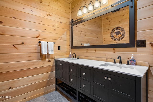 full bath with a sink, wooden walls, and double vanity