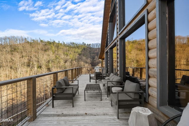 deck with a forest view and outdoor lounge area