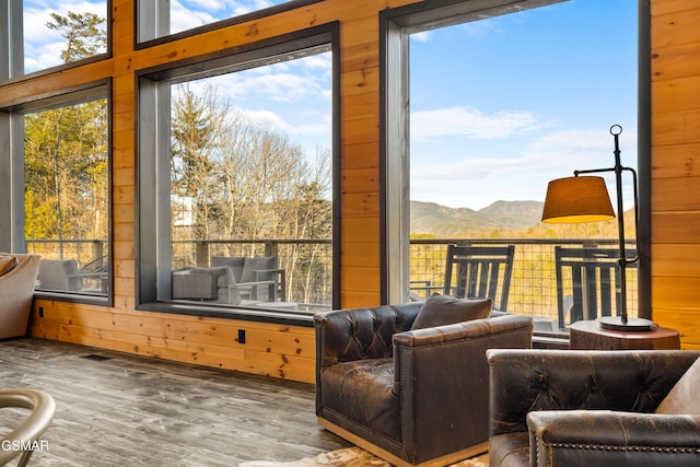 interior space featuring wooden walls, a mountain view, and wood finished floors