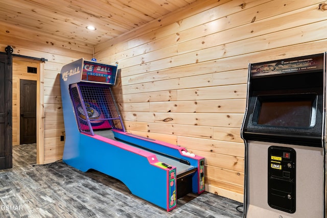 playroom with a barn door, wood ceiling, wood finished floors, and wood walls