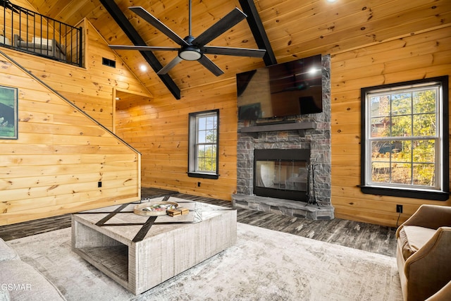 living room featuring wooden walls, beamed ceiling, and wooden ceiling