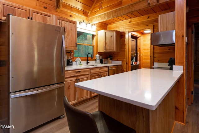 2069 Little Creek Way, Sevierville, TN 37862 - kitchen featuring freestanding refrigerator, a sink, under cabinet range hood, light wood-style floors, and wood walls
