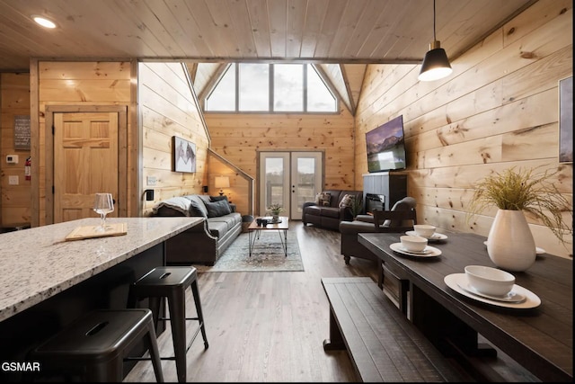 dining space featuring wooden ceiling, dark wood-type flooring, wooden walls, and french doors