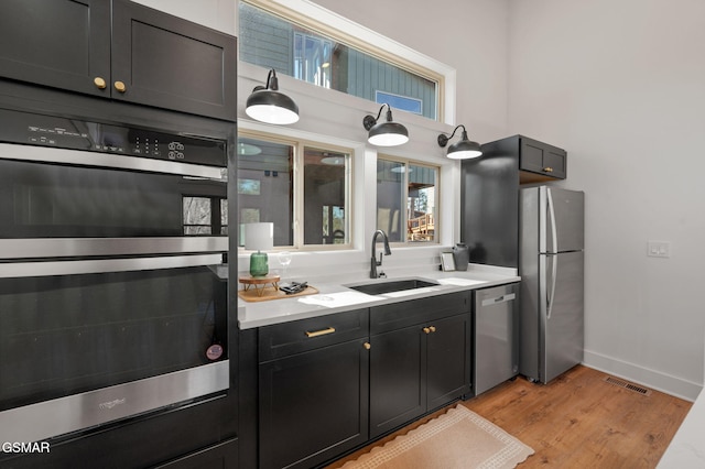 2385 Forge Hideaway Loop Unit 4, Pigeon Forge, TN 37863 - kitchen with stainless steel appliances, a sink, light wood-type flooring, baseboards, and light countertops