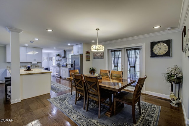 dining room with baseboards, a healthy amount of sunlight, ornamental molding, and dark wood finished floors