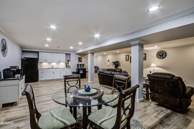 dining room featuring crown molding, recessed lighting, light wood-type flooring, and ornate columns