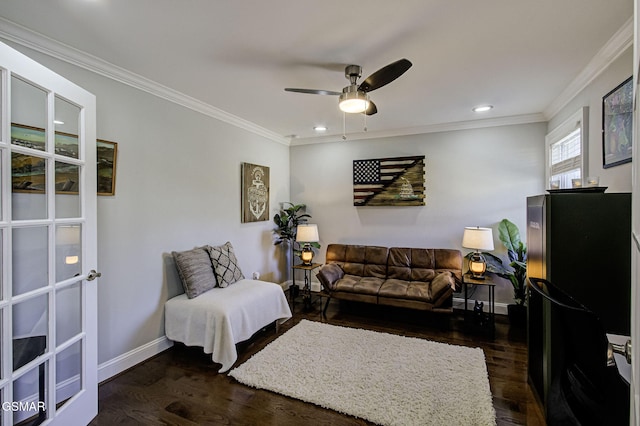 living room with a ceiling fan, dark wood-type flooring, baseboards, and ornamental molding