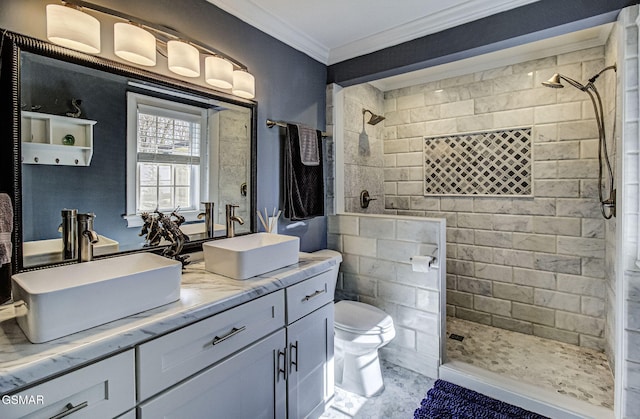 full bathroom featuring toilet, tiled shower, crown molding, and a sink