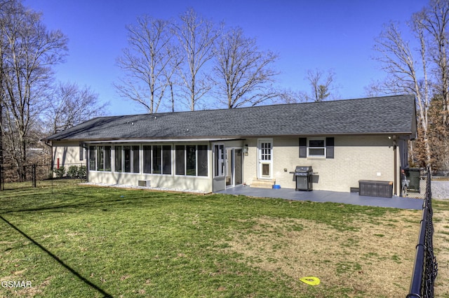 back of house with brick siding, fence, a yard, a sunroom, and a patio area