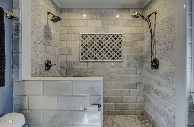 bathroom featuring tiled shower, toilet, and crown molding