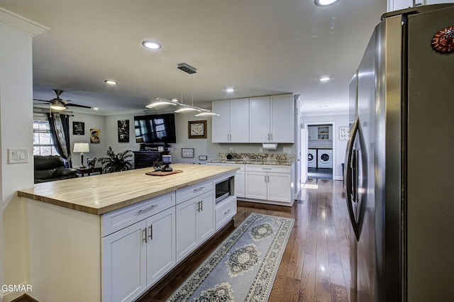 kitchen featuring dark wood finished floors, butcher block countertops, stainless steel appliances, white cabinetry, and separate washer and dryer