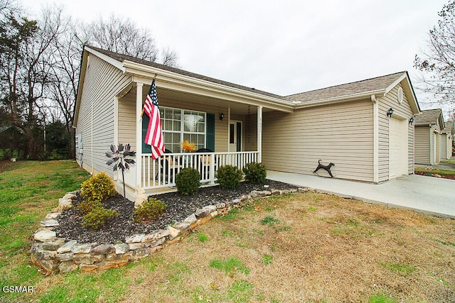 single story home with a porch, a garage, and a front yard