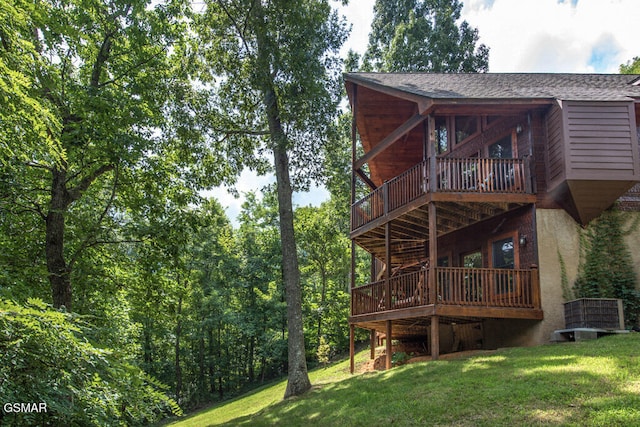 rear view of house featuring a yard and a balcony