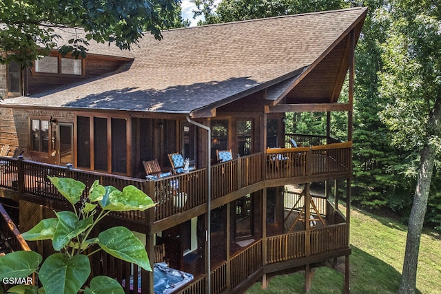 rear view of property featuring a deck and a sunroom