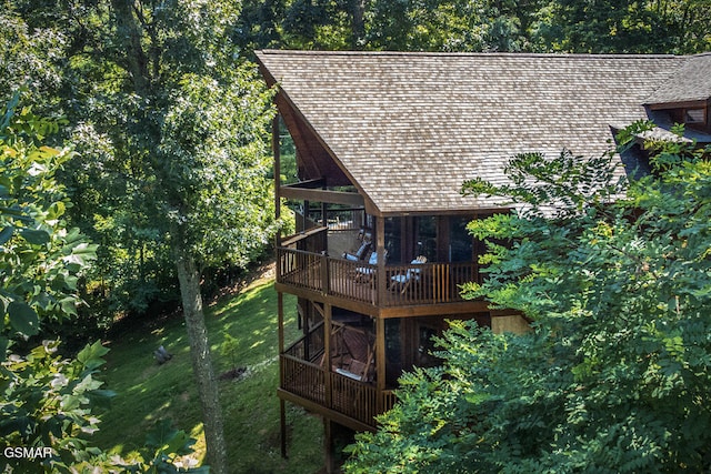 view of property exterior with a deck and a lawn