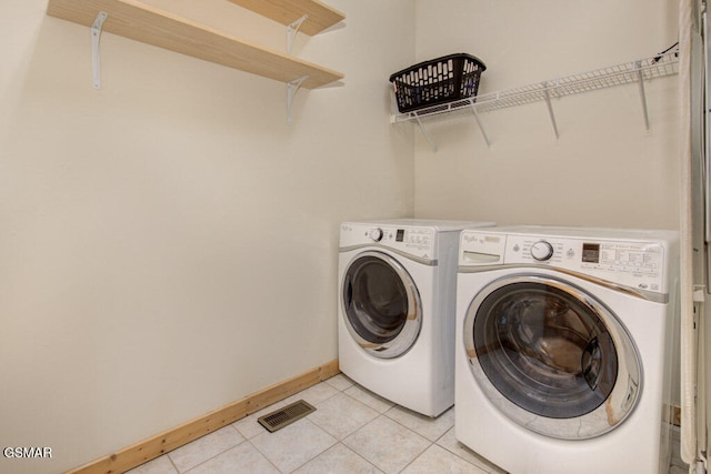 laundry area featuring washer and dryer and light tile patterned flooring