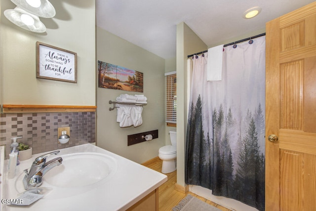 bathroom featuring vanity, backsplash, a shower with curtain, and toilet