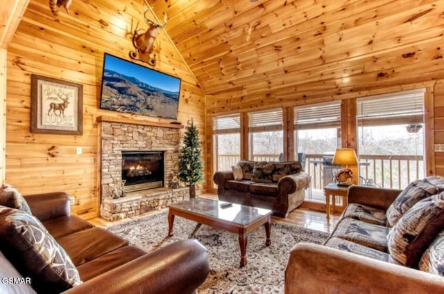 929 Smoky Ct, Gatlinburg, TN 37738 - living room with lofted ceiling, wood finished floors, wood walls, a stone fireplace, and wooden ceiling