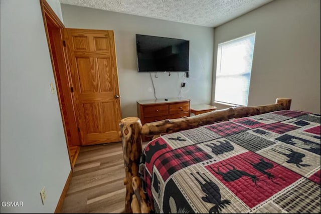 929 Smoky Ct, Gatlinburg, TN 37738 - bedroom with a textured ceiling, light wood-style floors, and baseboards