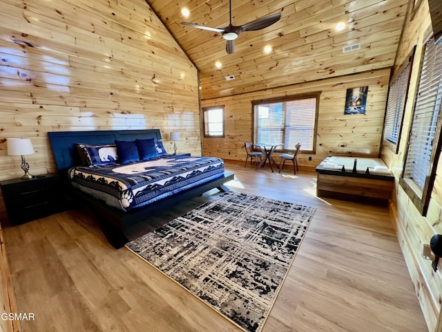 bedroom with wood walls, wooden ceiling, high vaulted ceiling, ceiling fan, and light wood-type flooring