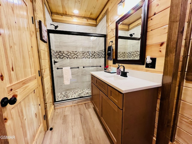 bathroom featuring walk in shower, wood ceiling, vanity, wooden walls, and hardwood / wood-style floors