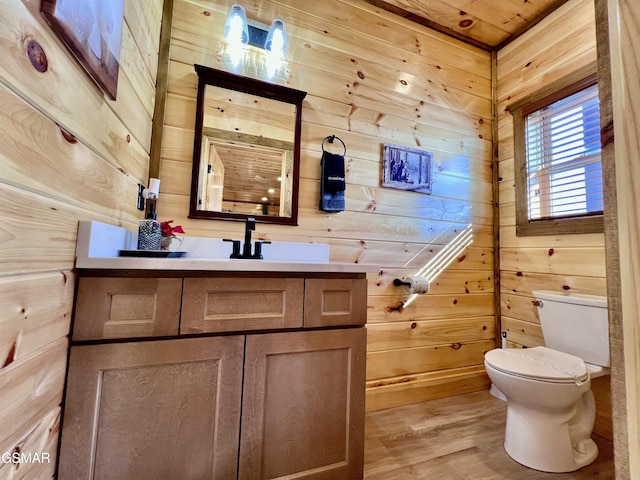 bathroom with vanity, hardwood / wood-style flooring, toilet, and wood walls