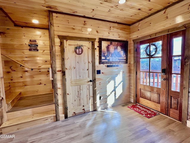 entryway with hardwood / wood-style flooring, wooden ceiling, and wood walls