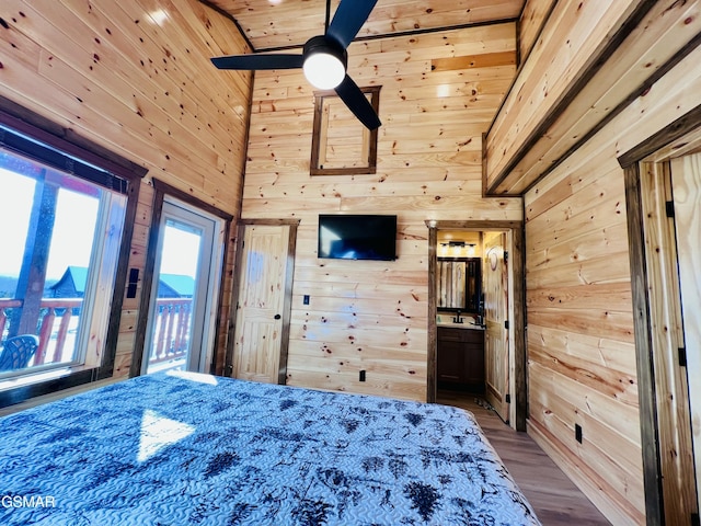 bedroom with ceiling fan, a towering ceiling, wood ceiling, and wood walls