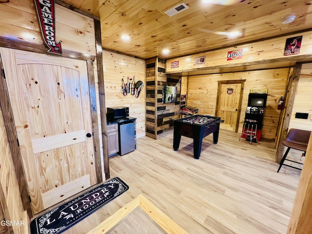 rec room featuring light hardwood / wood-style flooring, wood ceiling, and wood walls