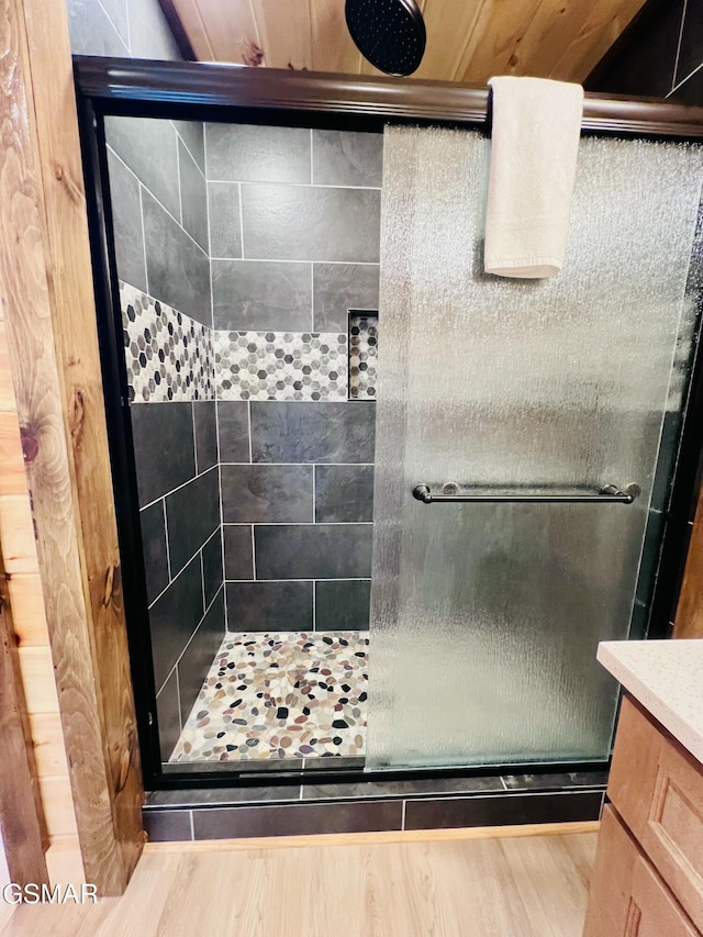 bathroom featuring hardwood / wood-style floors, vanity, and walk in shower