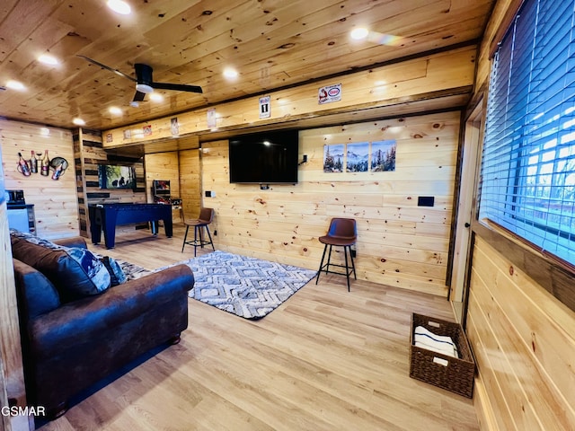 living room featuring hardwood / wood-style floors, ceiling fan, wood walls, and wood ceiling