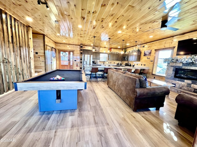 game room with wood ceiling, ceiling fan, wooden walls, light hardwood / wood-style floors, and pool table