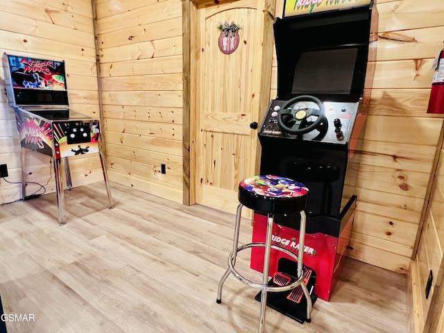 game room featuring hardwood / wood-style floors and wood walls