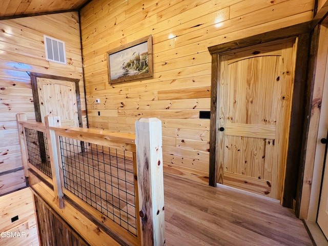 interior space featuring hardwood / wood-style floors and wooden walls