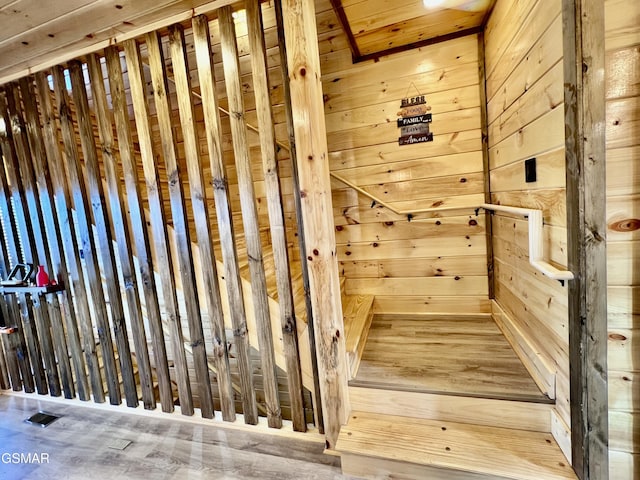 stairway featuring wood walls and hardwood / wood-style flooring