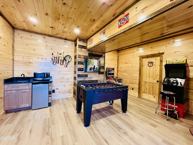 recreation room featuring wooden ceiling, light hardwood / wood-style flooring, wooden walls, and sink